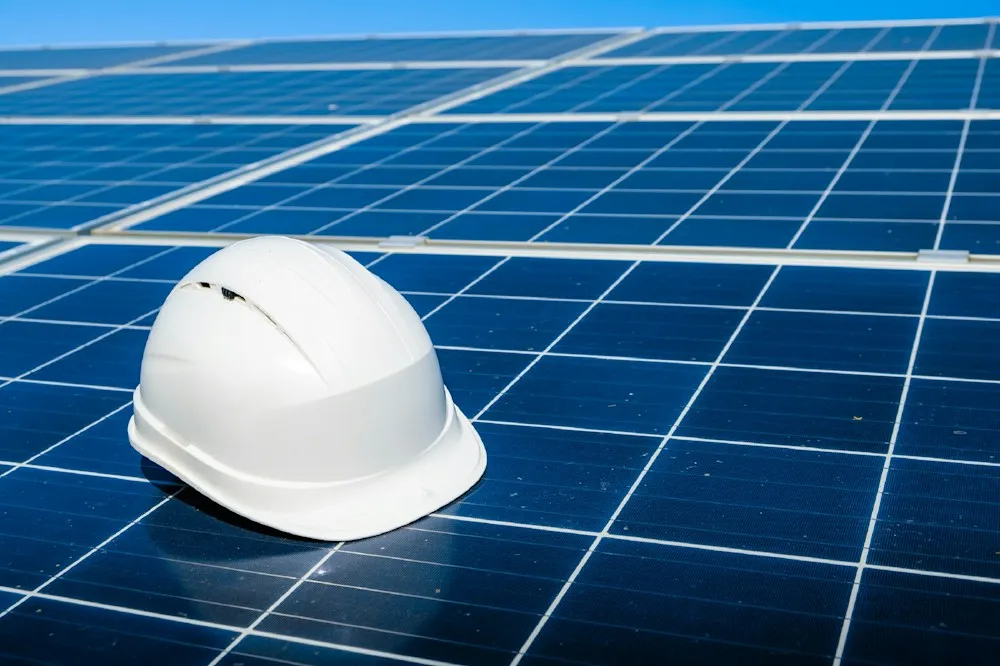Safety helmet resting on a solar panel during installation
